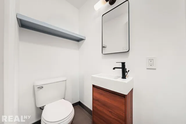 a bathroom with a toilet a sink and mirror