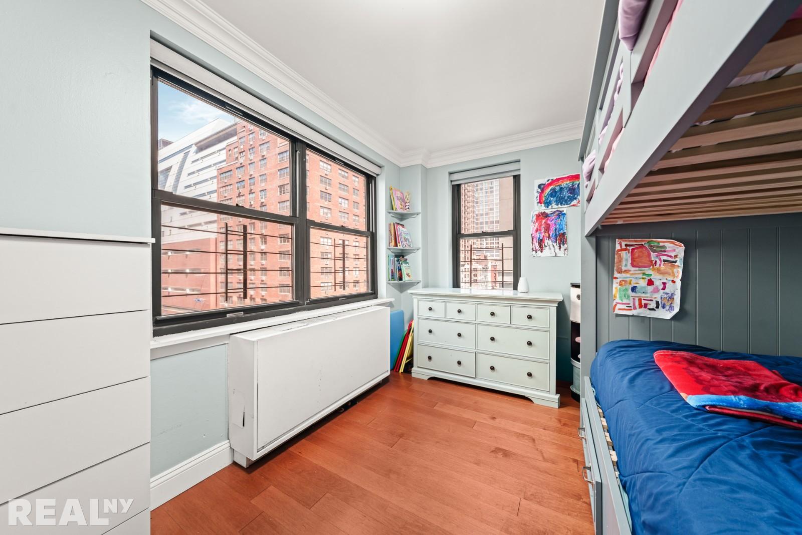 200 East 24th Street, Unit 706 Manhattan, NY 10010 - Photo 8 of 17 a view of a bedroom with furniture and a window