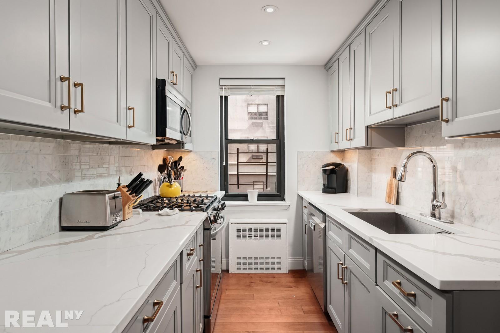 200 East 24th Street, Unit 706 Manhattan, NY 10010 - Photo 9 of 17 a kitchen with a sink a stove and cabinets