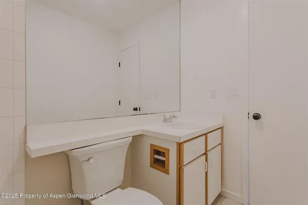 a utility room with a sink a toilet and vanity
