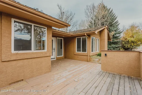 a backyard of a house with wooden floor and fence