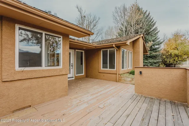 a backyard of a house with wooden floor and fence