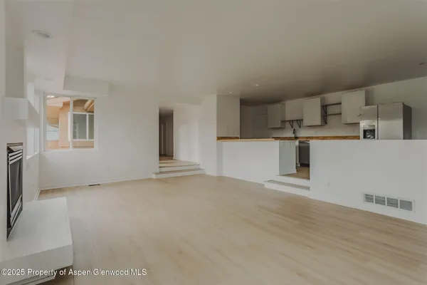 a view of a kitchen with a sink and a refrigerator