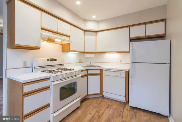a kitchen with a stove cabinets and wooden floor