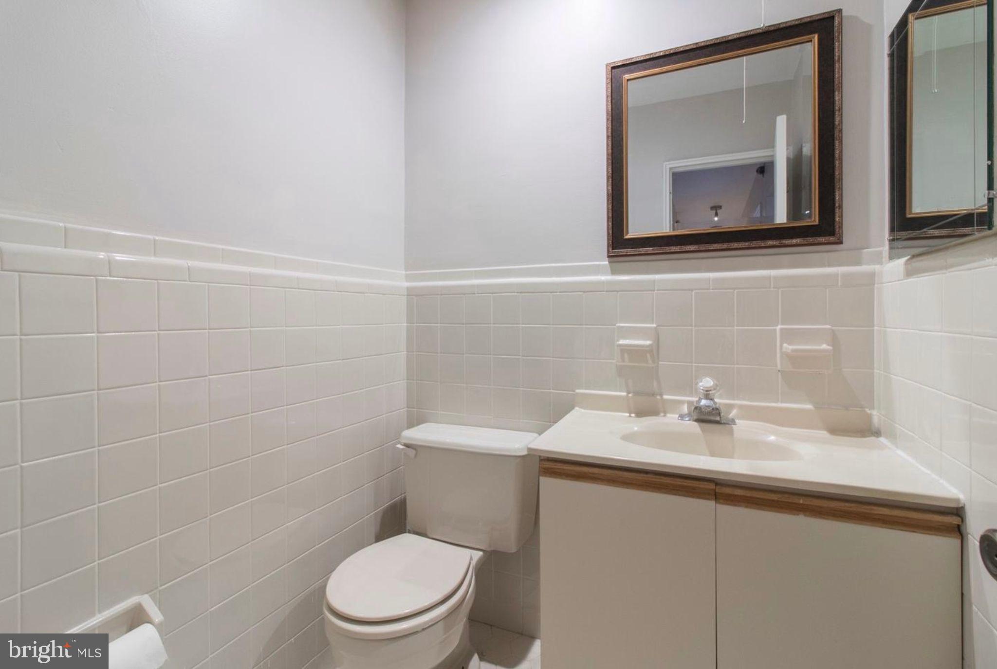 383 Lakeside Road, Unit 104 Ardmore, PA 19003 - Photo 9 of 18 a bathroom with a toilet sink and mirror