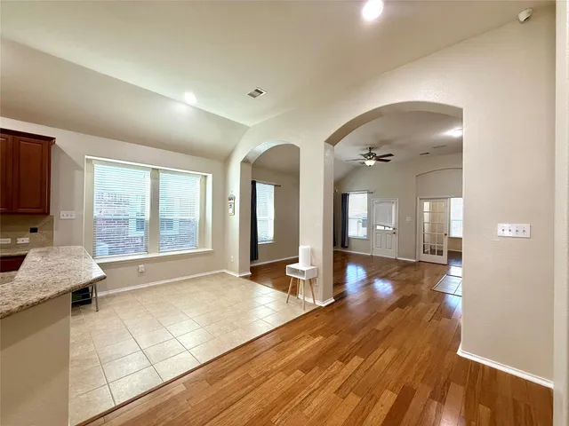 a view of a hall with wooden floor and a large window