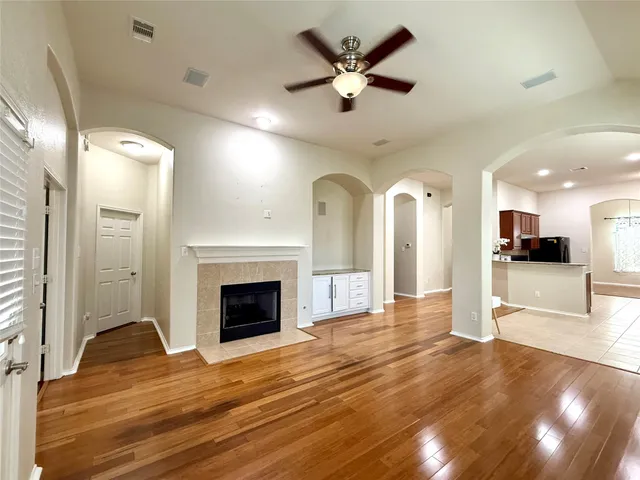 a view of a big room with wooden floor and a kitchen