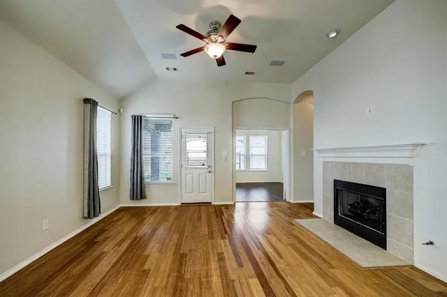 a view of empty room with wooden floor and fireplace
