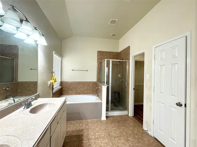 a bathroom with a tub sink and mirror