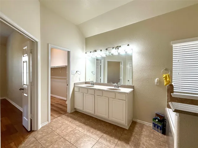 a spacious bathroom with a double vanity sink and a mirror