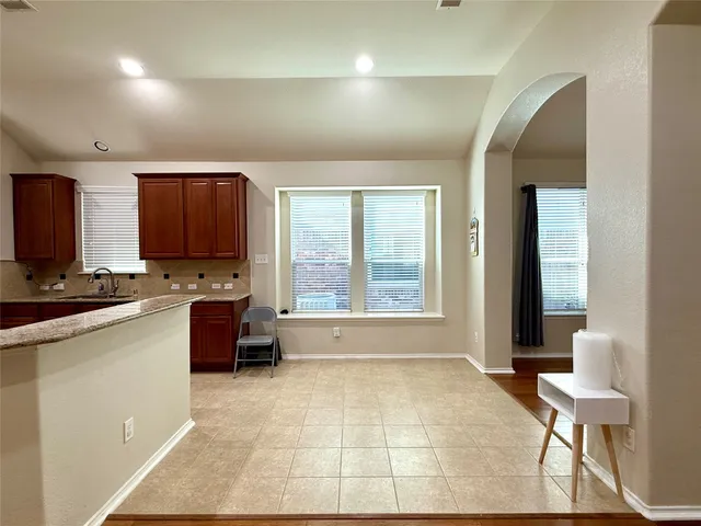 a large kitchen with granite countertop a large stove a sink a window and dining table