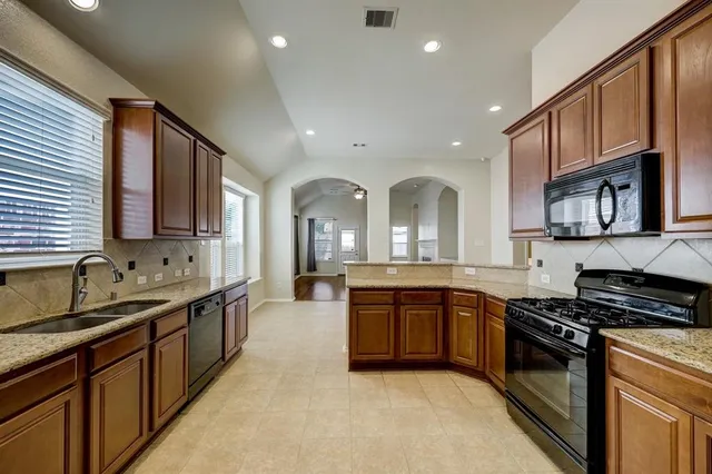 a large kitchen with stainless steel appliances granite countertop a stove and a sink