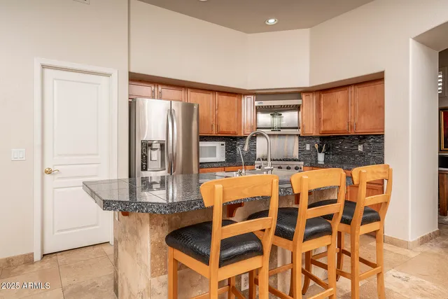 a kitchen with stainless steel appliances granite countertop a stove a sink and a refrigerator