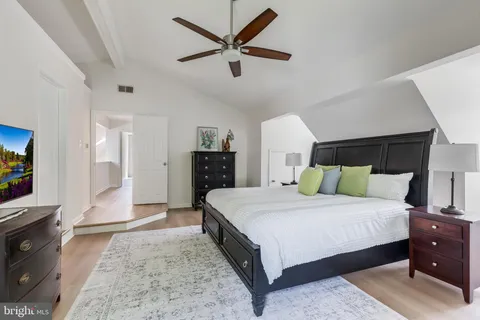 a bedroom with a bed a couch and a potted plant