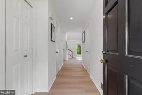a view of a hallway with wooden floor and staircase