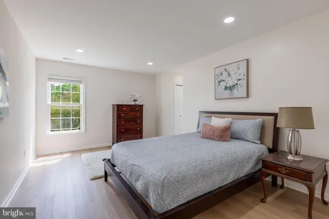 a spacious bedroom with a bed and a potted plant