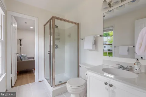 a bedroom with a bed and a lamp on table with wooden floor