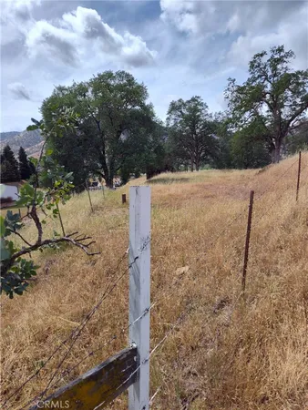 a view of a yard with wooden fence