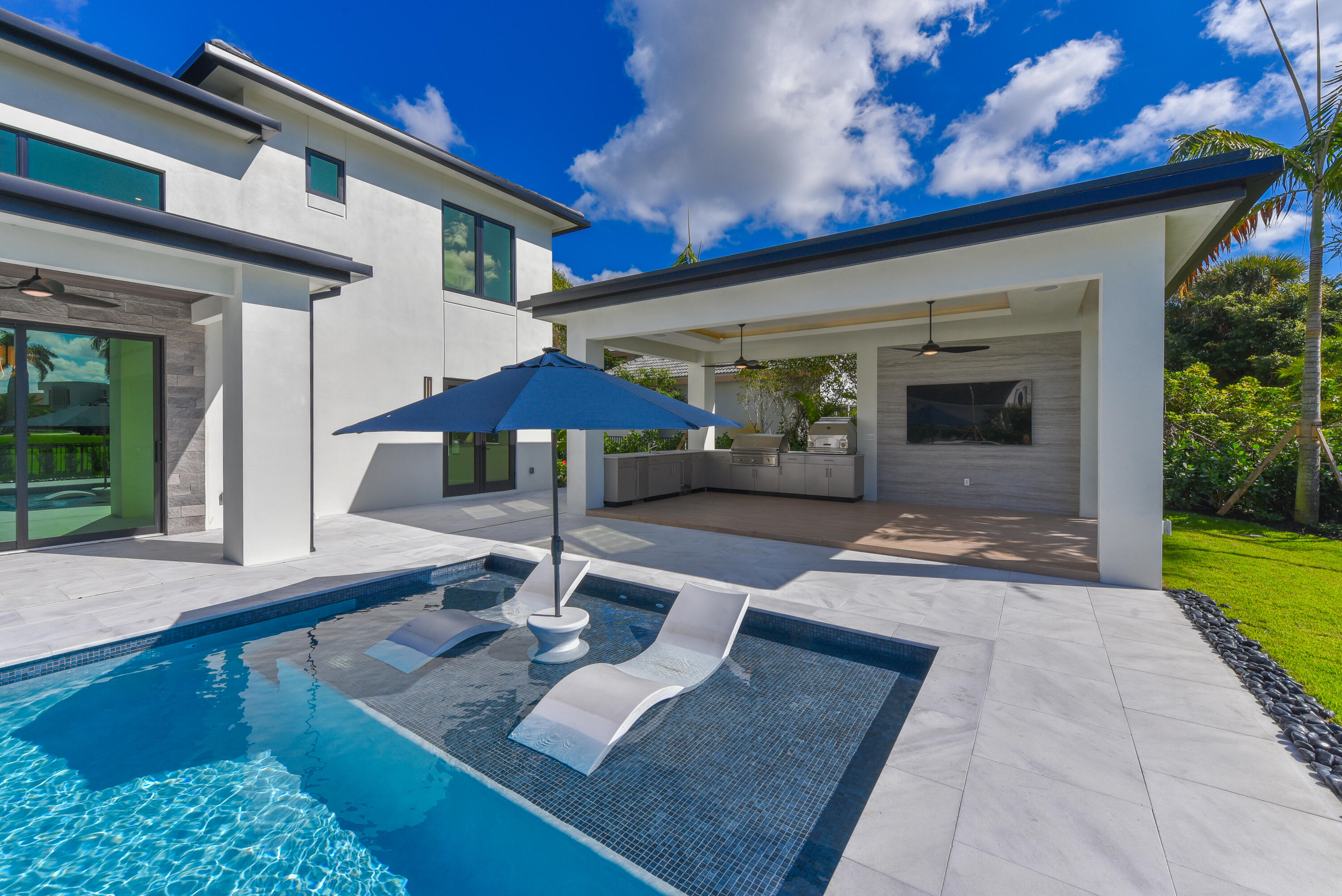 17577 Scarsdale Way Boca Raton, FL 33496 - Photo 70 of 145 a patio with a table and chairs under an umbrella