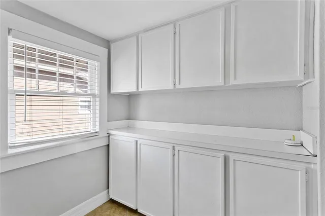 a view of an empty room with wooden floor fireplace and a window