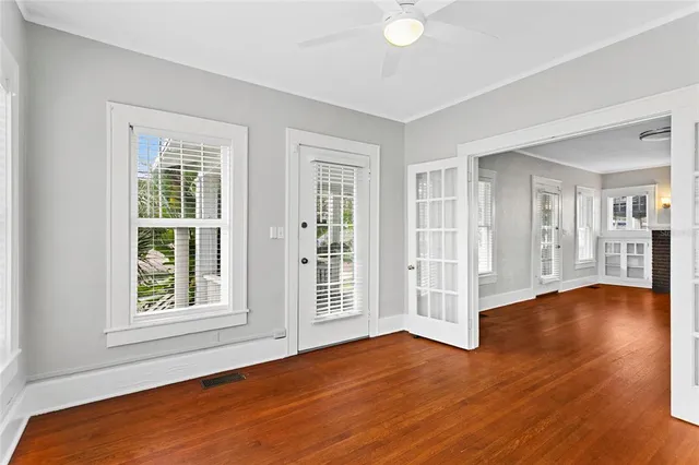 an empty room with wooden floor and windows