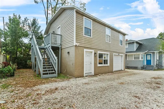 a view of a house with wooden fence and iron stairs