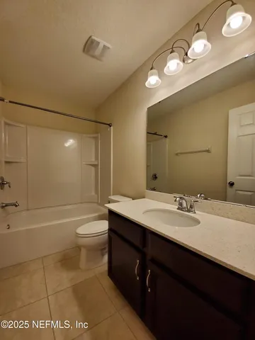 a bathroom with a sink a toilet a mirror and shower