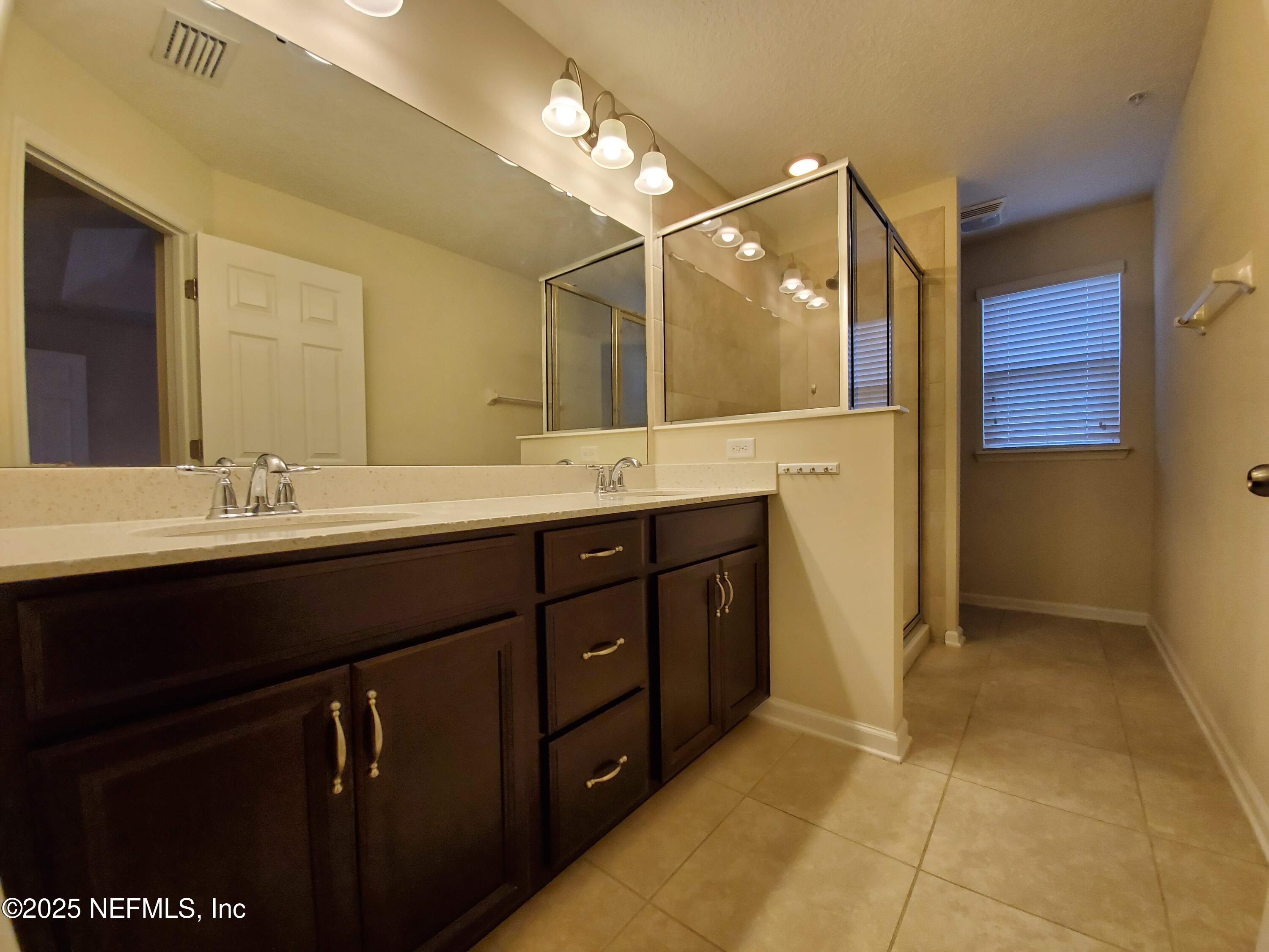 13 La Paz Way St. Augustine, FL 32092 - Photo 9 of 24 a bathroom with a double vanity sink a mirror and shower