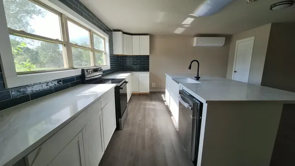 a view of kitchen with stainless steel appliances granite countertop a sink and a stove
