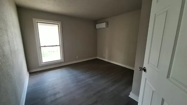 an empty room with windows and closet