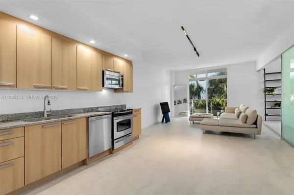 a kitchen with granite countertop a stove and white cabinets