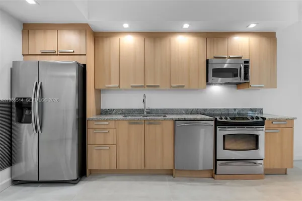 a kitchen with granite countertop stainless steel appliances and wooden cabinets