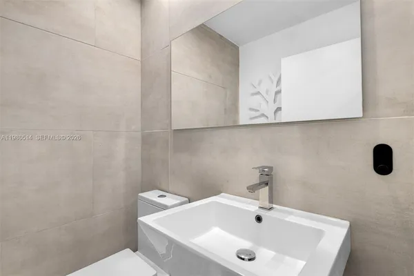 a bathroom with a sink a toilet and mirror