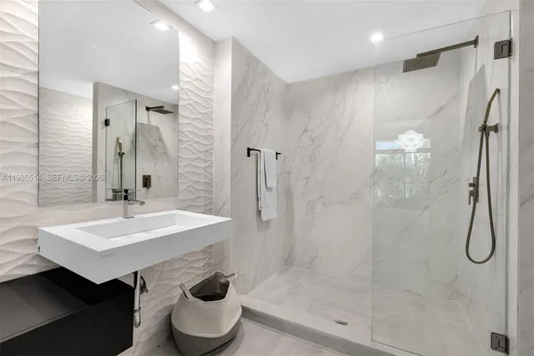 a bathroom with a sink a toilet and shower