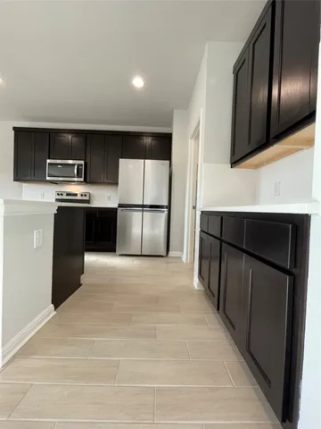 a kitchen with stainless steel appliances a refrigerator and a stove top oven