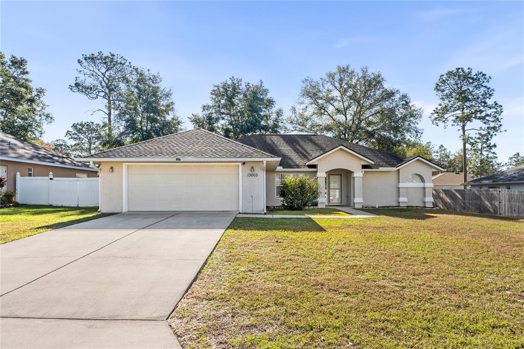 13005 60th Court Road Ocala, FL 34473 - Photo 1 of 1 a front view of a house with a yard and garage