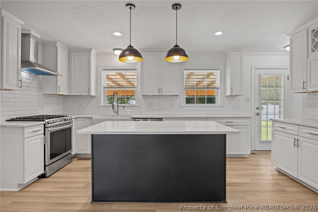 309 Cornith Road Pembroke, NC 28372 - Photo 16 of 49 a kitchen with stainless steel appliances granite countertop a sink a stove a refrigerator wooden floor and a window