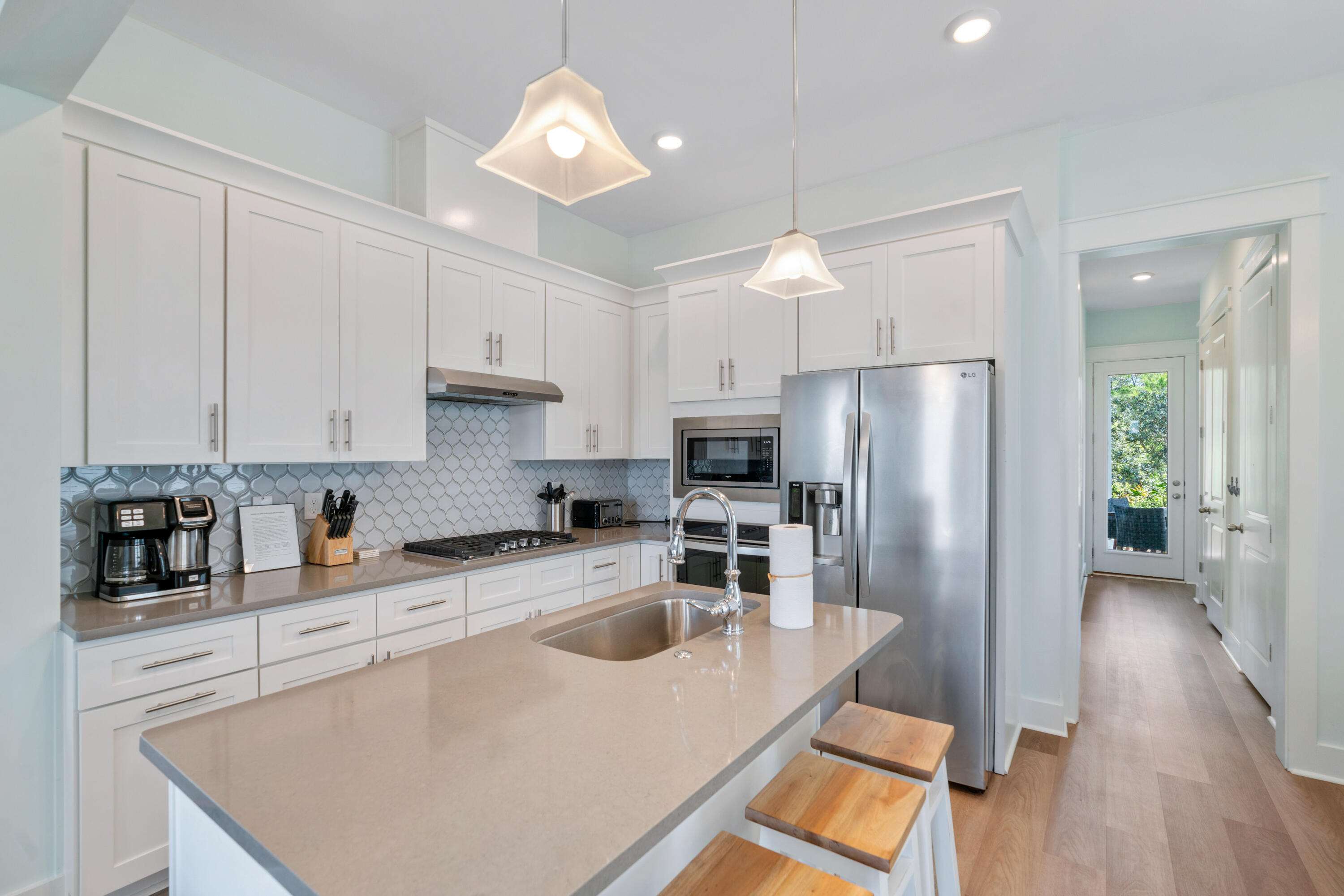 30 Constant Avenue Santa Rosa Beach, FL 32459 - Photo 10 of 51 a kitchen with stainless steel appliances granite countertop a refrigerator a sink a stove and white cabinets with wooden floor