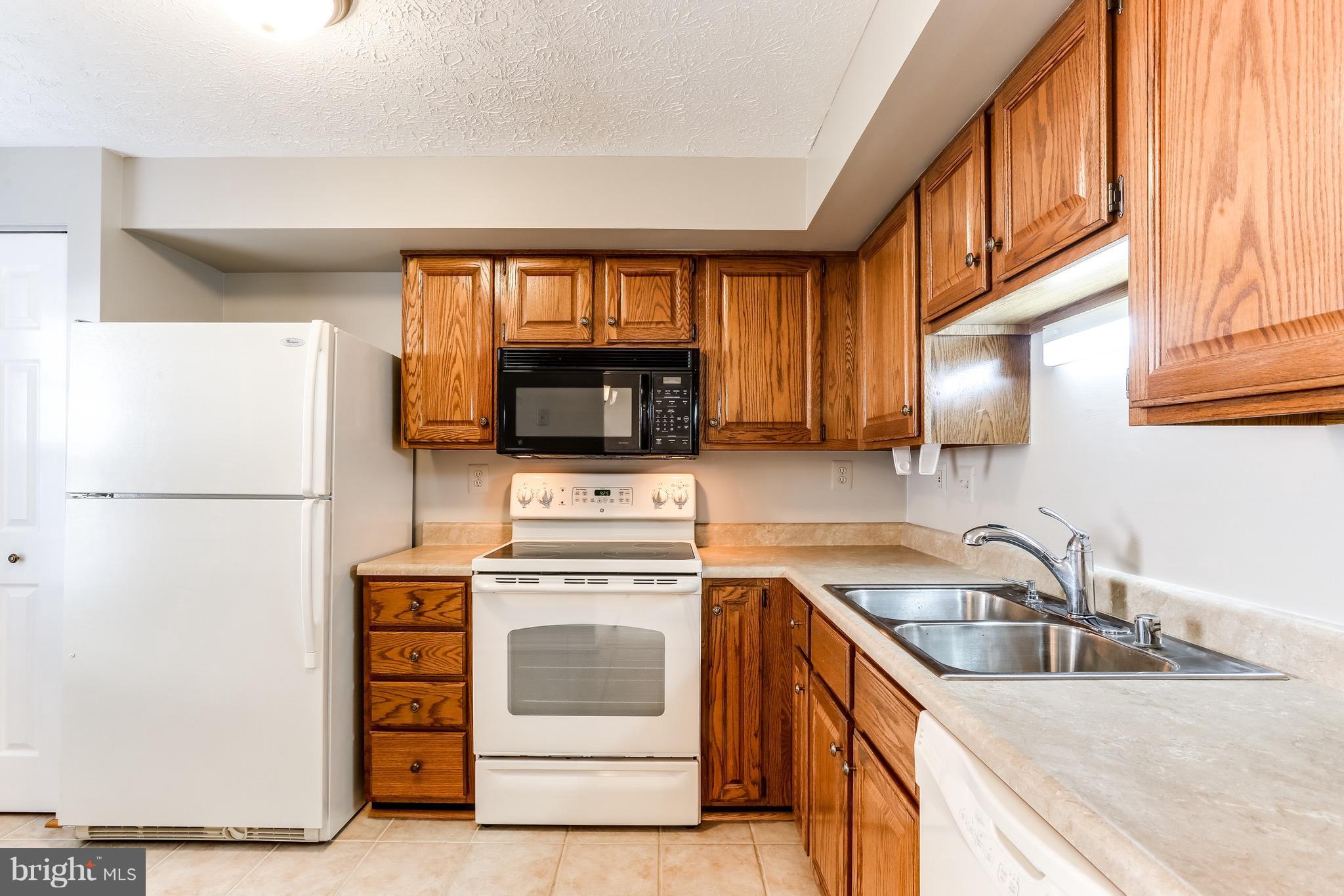 6 Ramsgate Court Halethorpe, MD 21227 - Photo 15 of 29 a kitchen with a stove a sink and a microwave