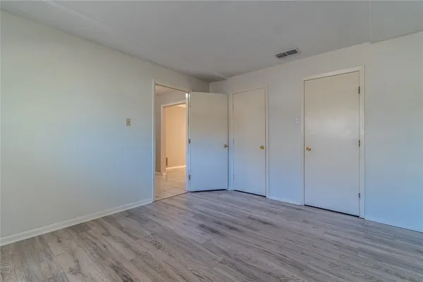 wooden floor in an empty room with a ceiling fan