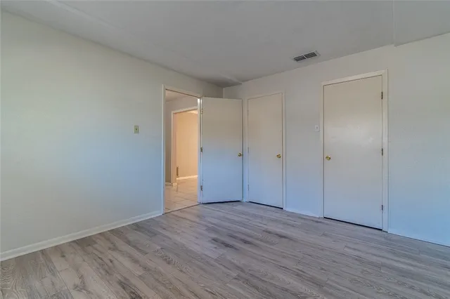 wooden floor in an empty room with a ceiling fan