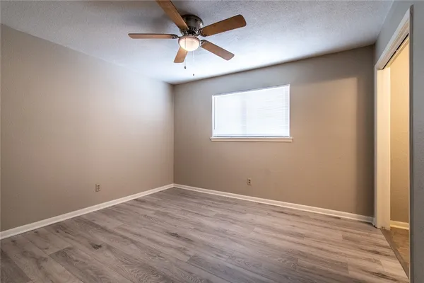 a view of a room with wooden floor and a ceiling fan