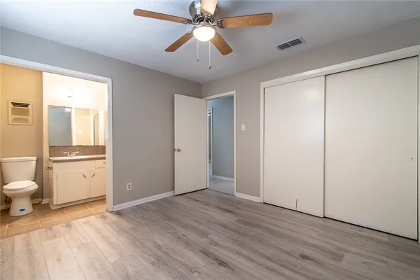 a bathroom with a granite countertop sink toilet and mirror