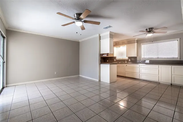 a kitchen with white cabinets a sink a stove and a window