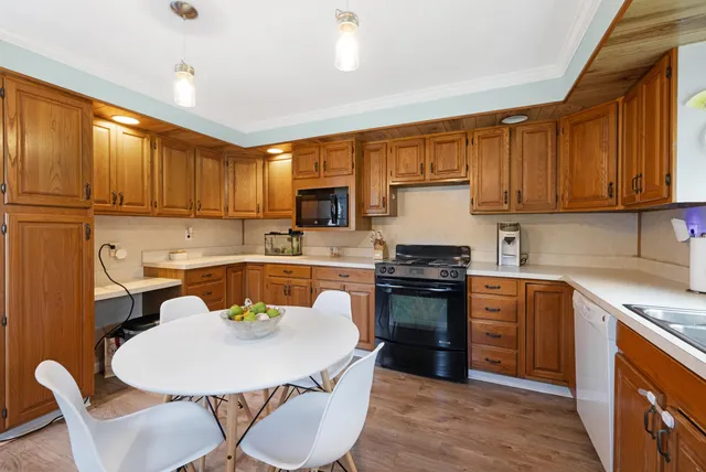 a kitchen with a stove a sink a dining table and chairs