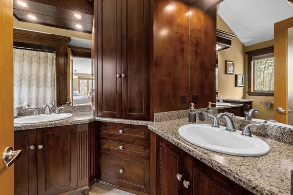 a bathroom with a granite countertop sink and a mirror