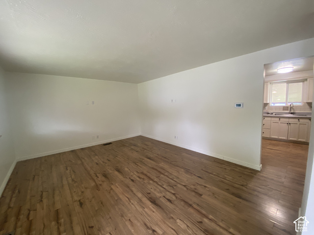 2989 Rae Street West Valley City, UT 84120 - Photo 5 of 25 Wood-finish flooring throughout, white wall finishes, and a kitchen with light cabinetry