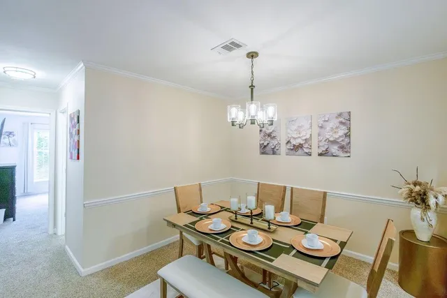 a view of a dining room with furniture wooden floor and a chandelier