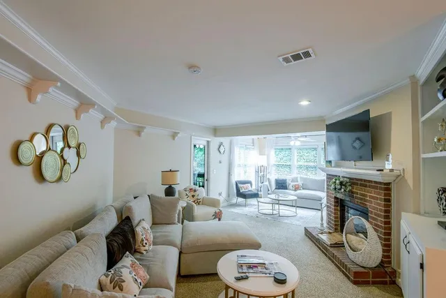 a living room with furniture a fireplace and a floor to ceiling window