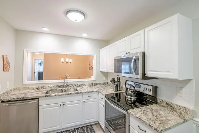 a kitchen with granite countertop a stove sink and cabinets